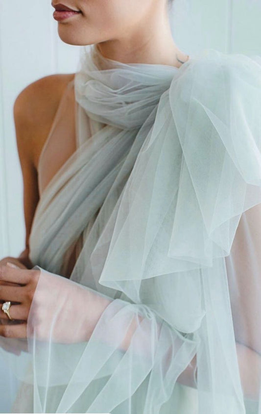 Model wearing a sheer tulle dress layered over a fitted base, highlighting light transparency and soft movement inspired by Spring runway fashion.