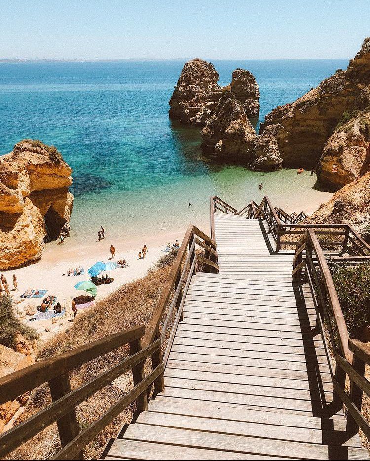 Wooden staircase descending to a secluded beach in the Algarve, Portugal