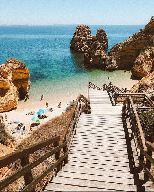 Wooden staircase descending to a secluded beach in the Algarve, Portugal